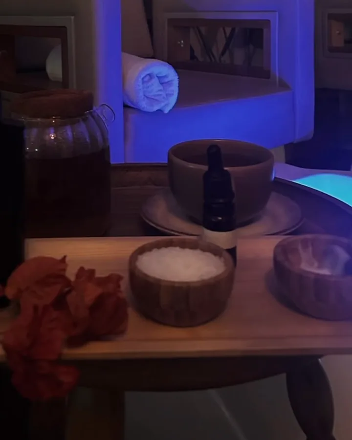 Bandeja com sais minerais, óleos essenciais e toalhas sob a luz azul
